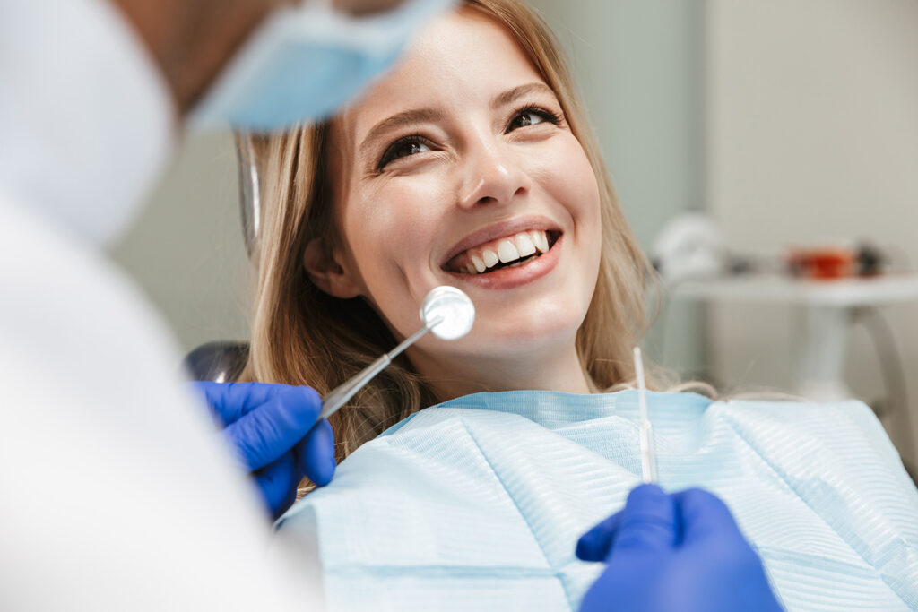 Dentist examining a smiling patient’s teeth