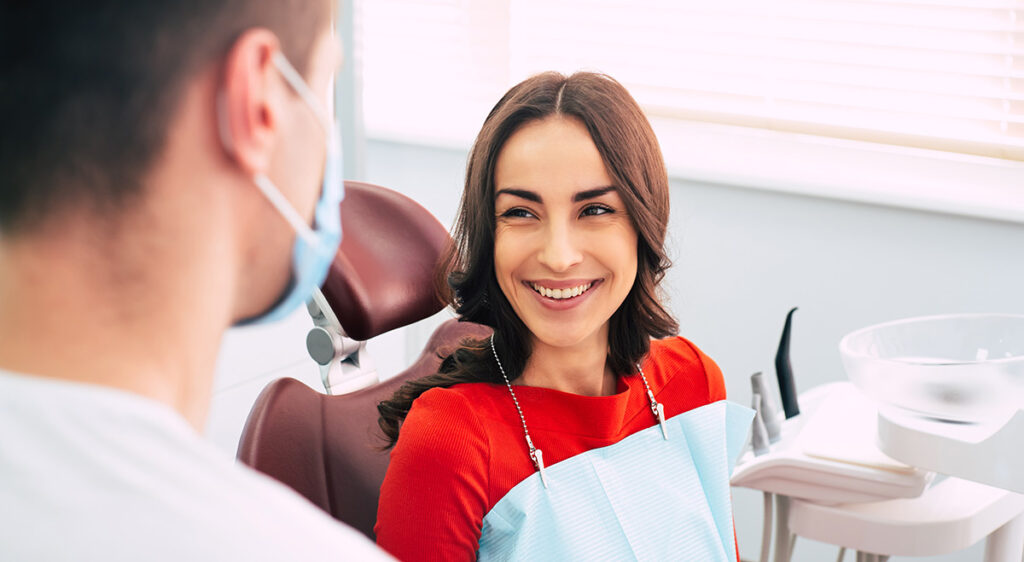 Smiling patient speaking with her dentist