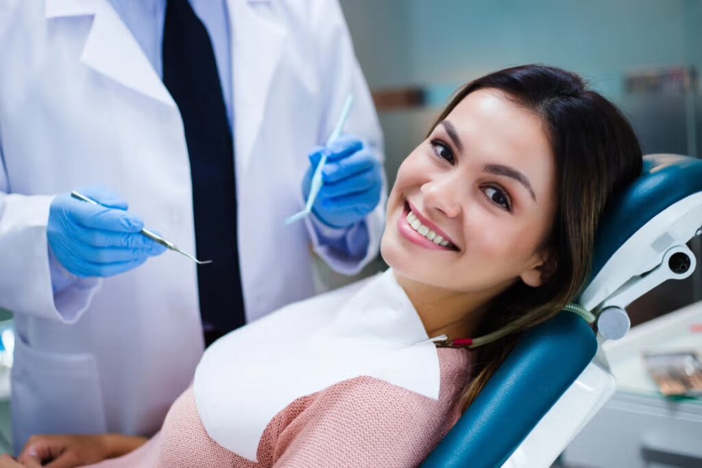 Smiling patient seated in a dental chair during an exam