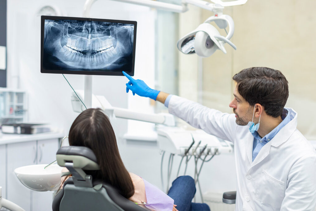 Dentist reviewing digital dental images with a seated patient