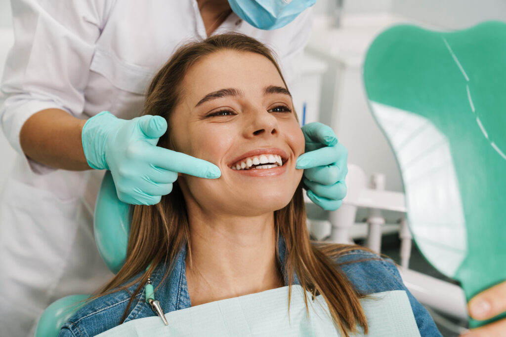 Dentist showing a patient her smile in a handheld mirror